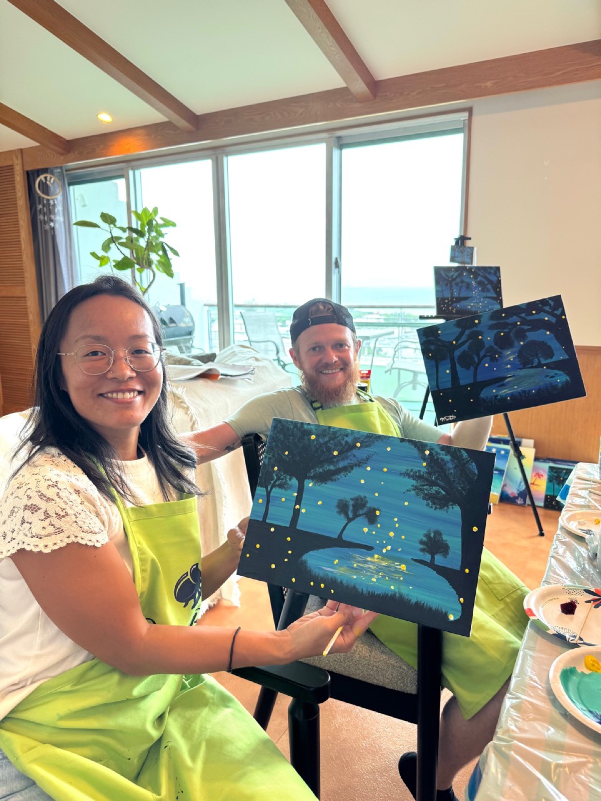 Two Pinto Beetle guests smiling with their finished firefly forest paintings