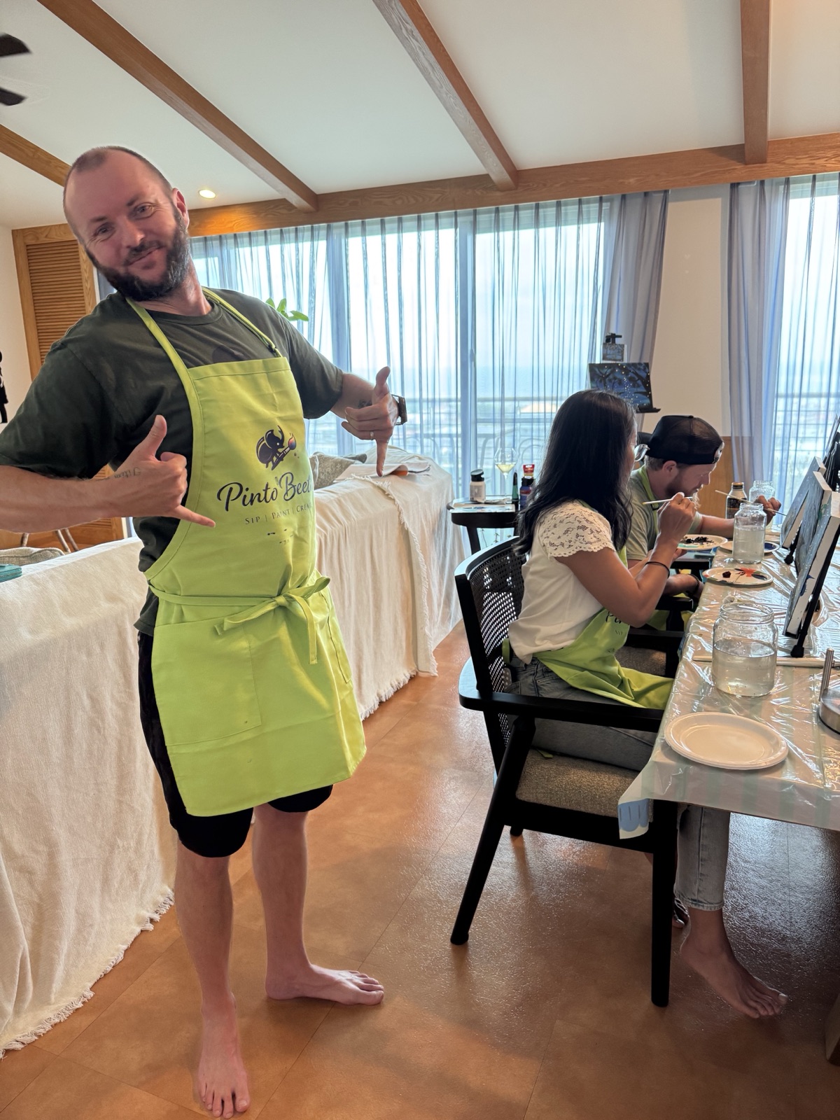 Pinto Beetle guest wearing a green apron during a relaxed private painting session