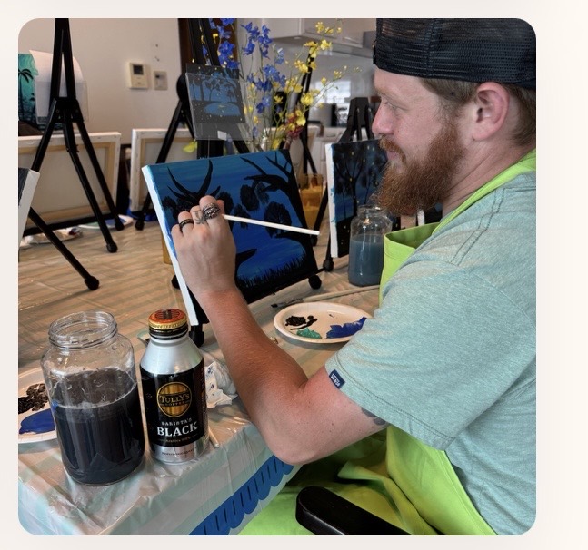 Pinto Beetle guest painting a blue canvas during class