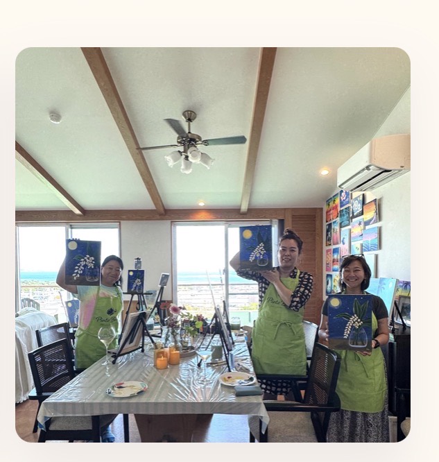 Pinto Beetle guests holding finished moonlit getto paintings in the ocean-view studio