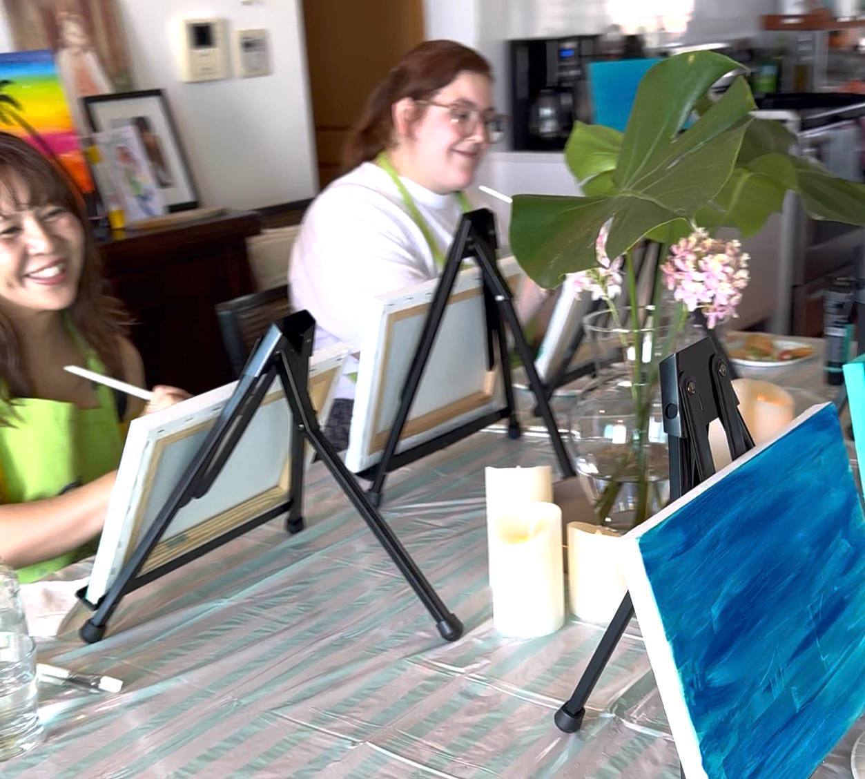 Two Pinto Beetle guests painting together at the class table