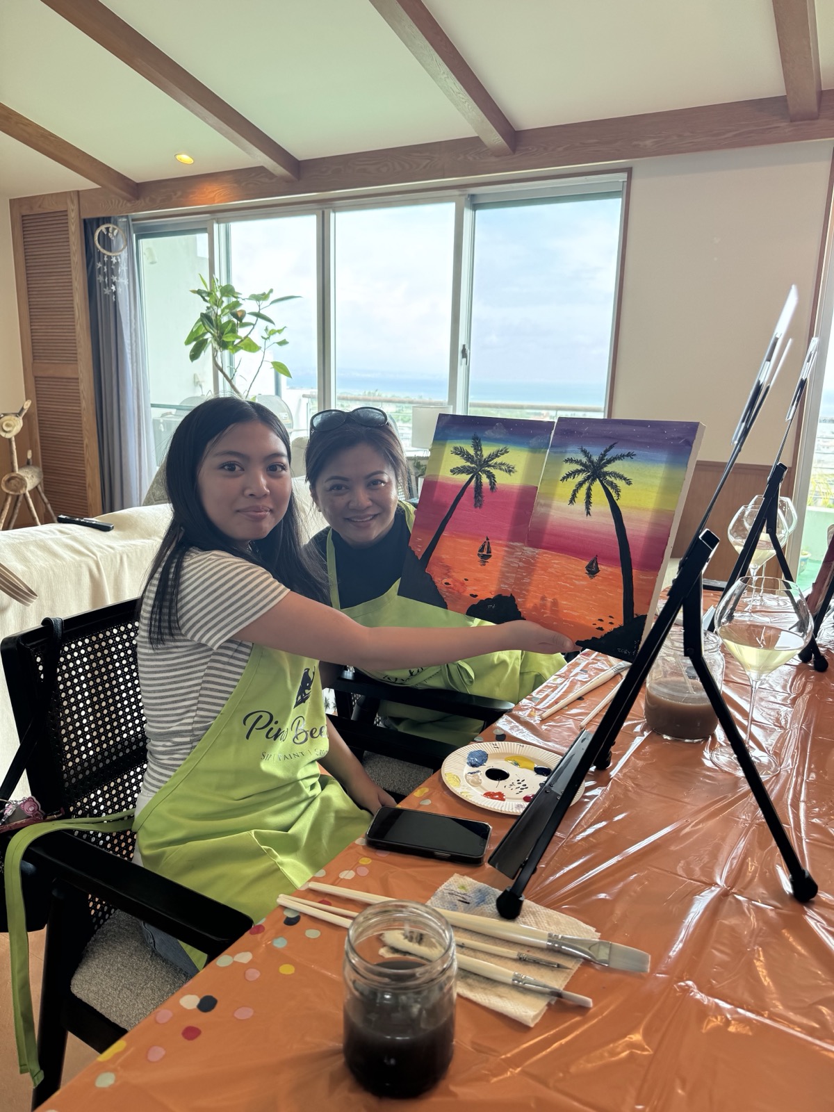Two Pinto Beetle guests smiling with their finished sunset paintings