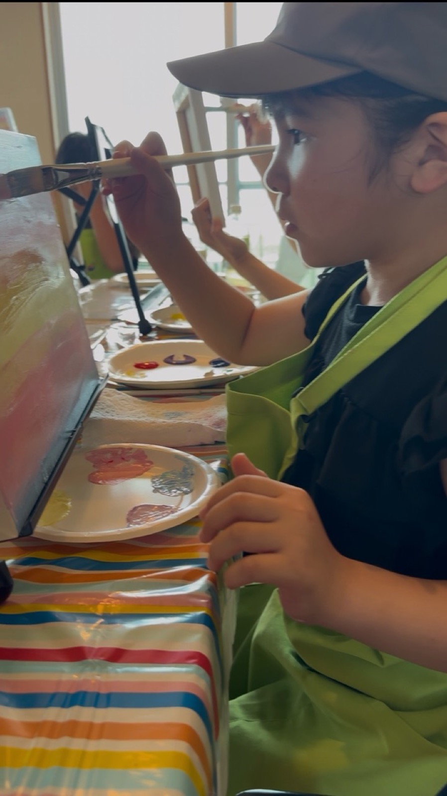 Young Pinto Beetle guest carefully painting a sunset canvas