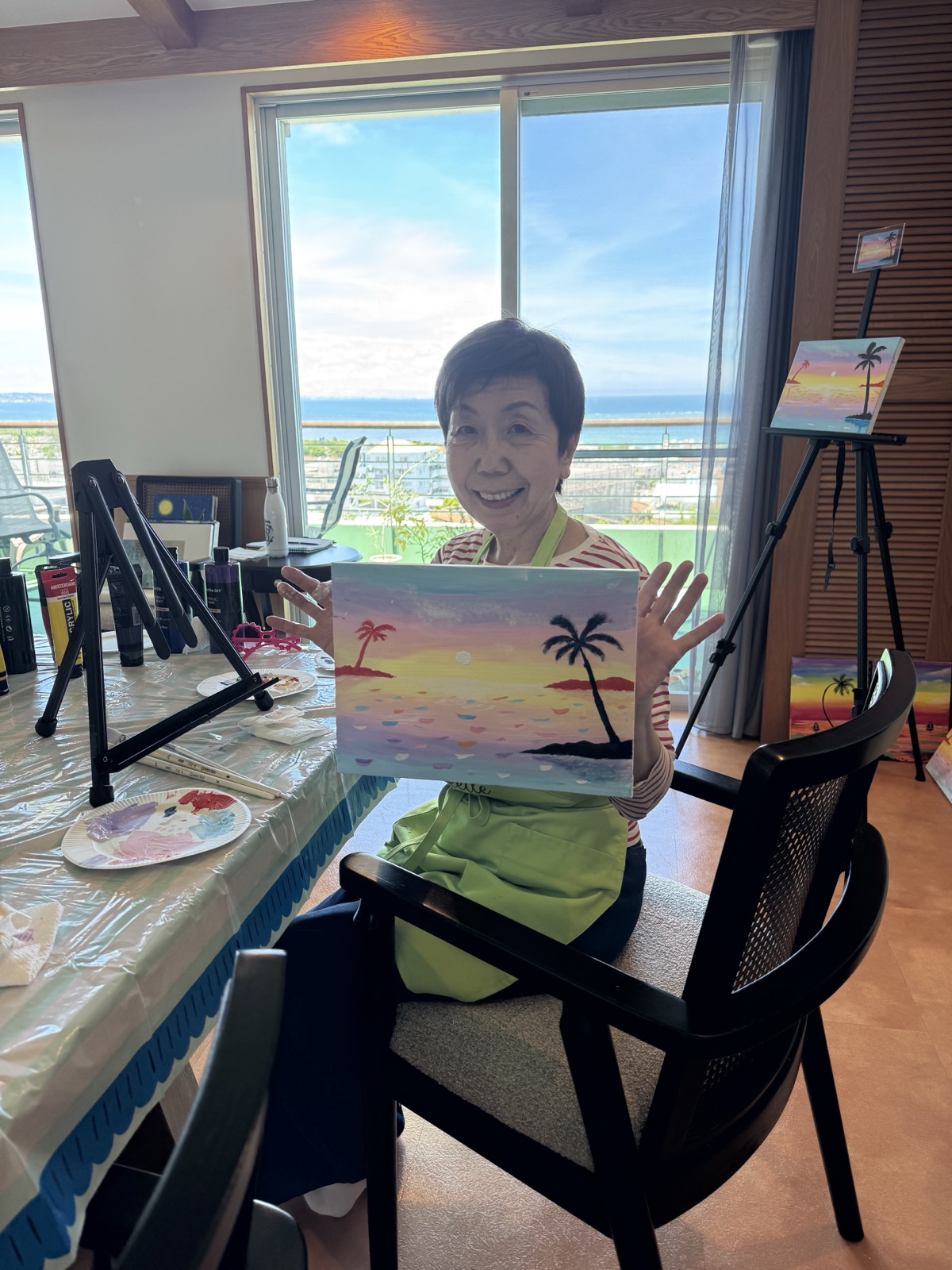 Pinto Beetle guest smiling with her finished tropical sunset painting