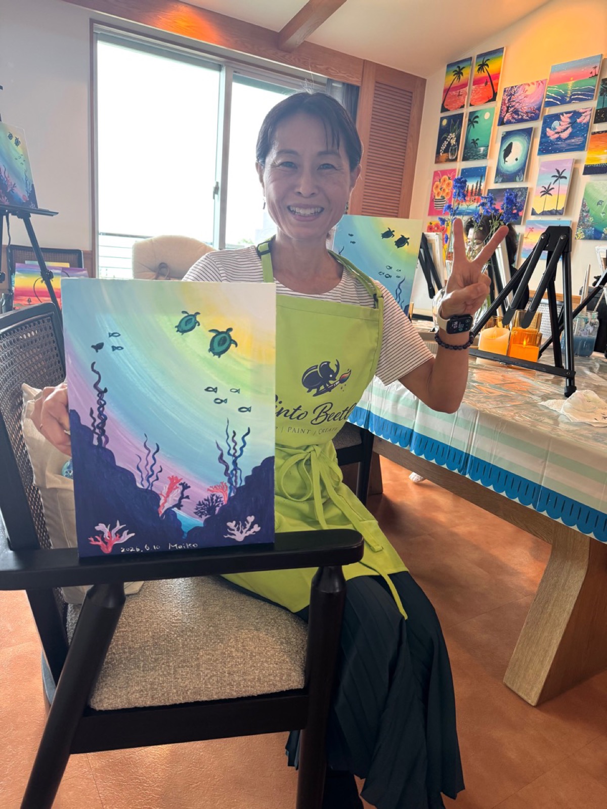 Pinto Beetle guest smiling beside her finished sea turtle painting