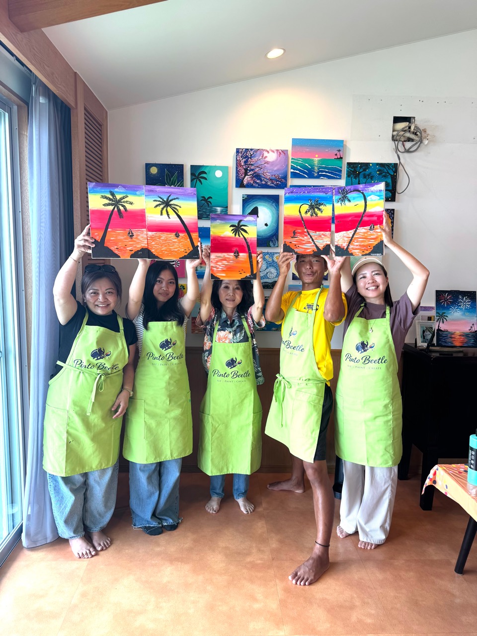 Pinto Beetle guests holding finished Tropical Sunset paintings